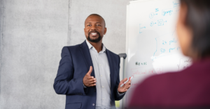 Man at work presenting metrics on a whiteboard. 