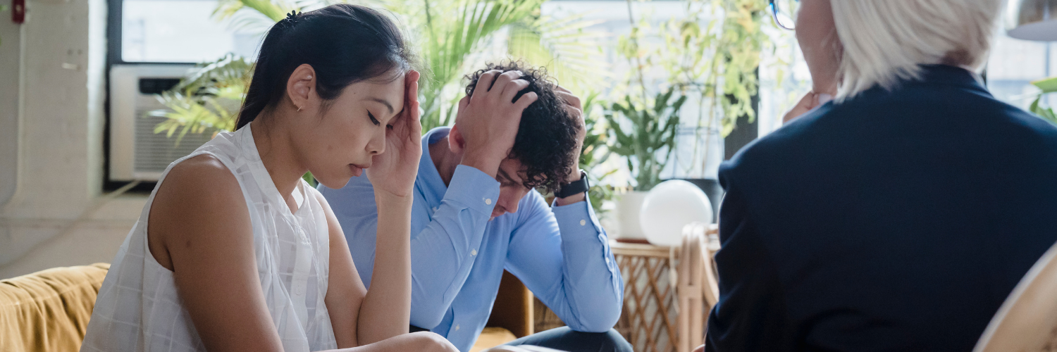 a distressed looking man and women in a work meeting